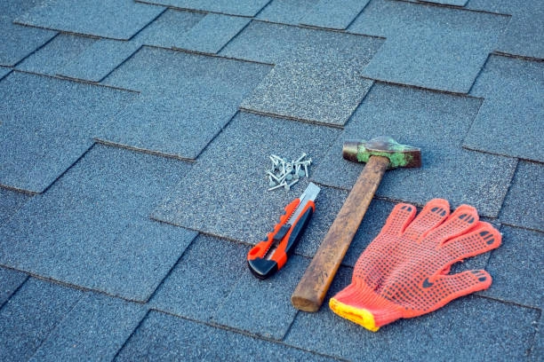 Roofing tools on shingles: hammer, gloves, nails, and cutter. -tile roofing contractors