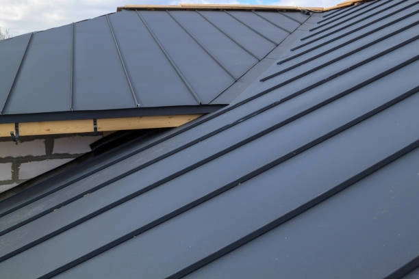 Modern metal roof with sleek panels and black standing seams. -commercial roofer