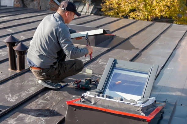 Worker installing or repairing a skylight on a metal roof. -roof repair phoenix az